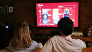 couple watching a movie on a large screen TV with a sound system